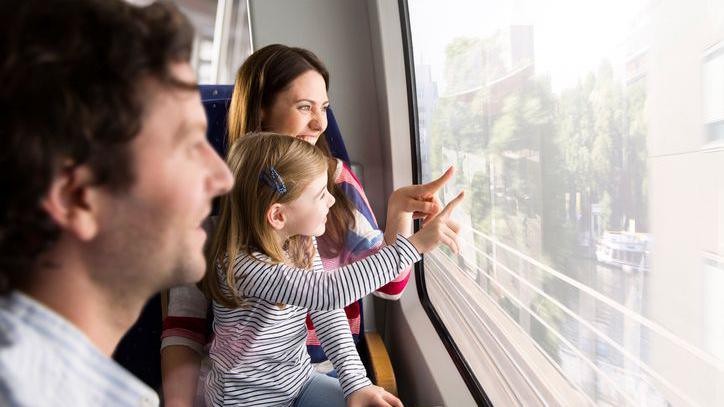 A family looking out of the window of a moving train